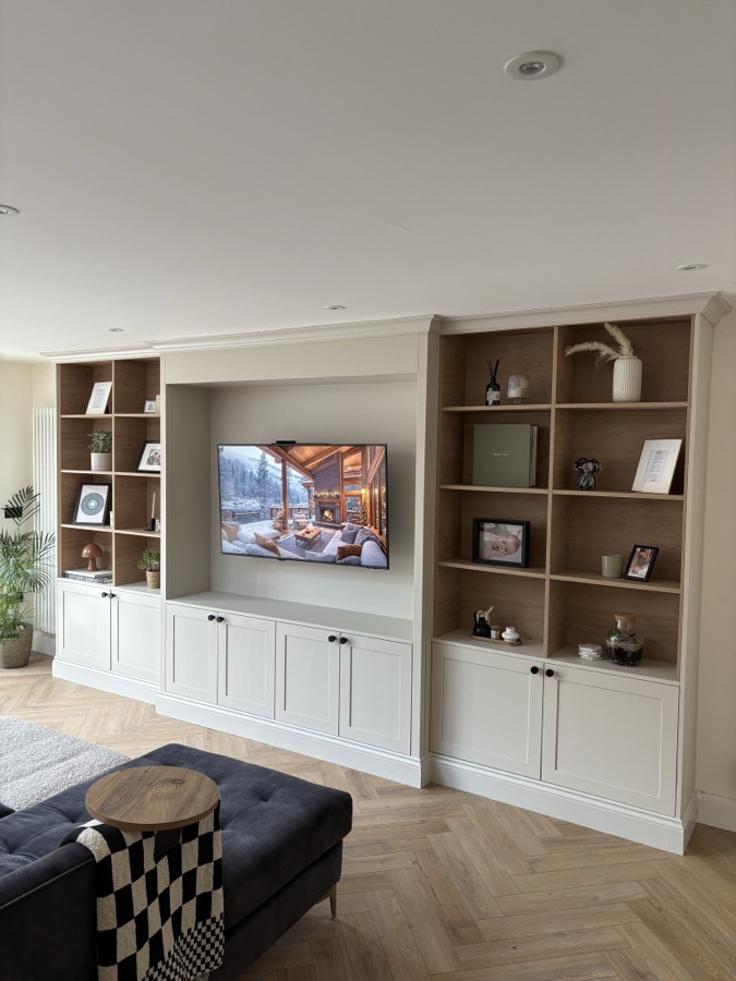 White shaker fitted media wall with oak cubby display shelves and herringbone floor